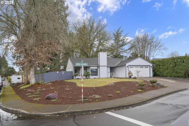 ranch-style home with an attached garage, fence, driveway, and a chimney