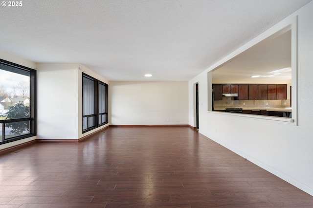 unfurnished living room with recessed lighting, baseboards, and dark wood-style floors