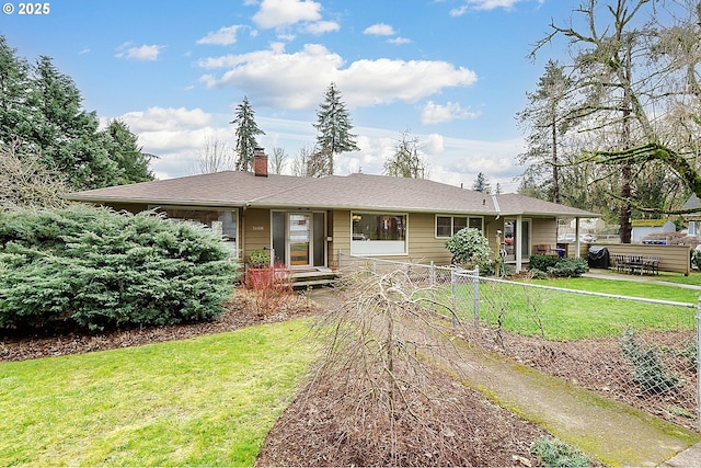 view of front of home with a patio, a chimney, a front yard, and fence