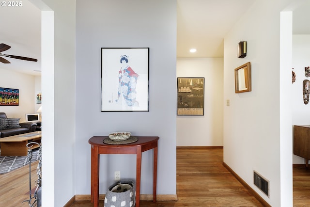 corridor with recessed lighting, visible vents, baseboards, and wood finished floors