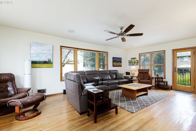 living room featuring visible vents, a healthy amount of sunlight, light wood-style flooring, and a ceiling fan