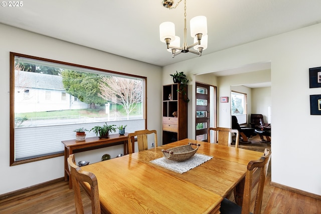 dining area featuring baseboards, an inviting chandelier, and wood finished floors