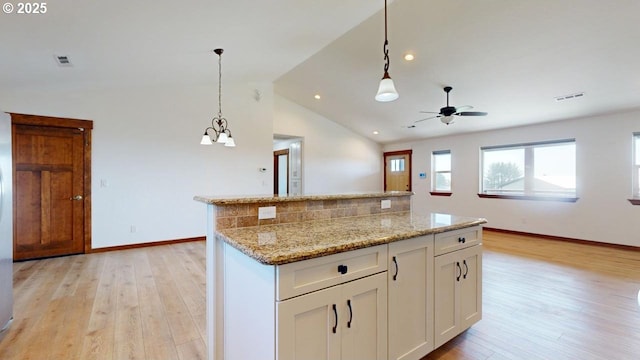 kitchen with white cabinetry, visible vents, vaulted ceiling, and light wood-type flooring