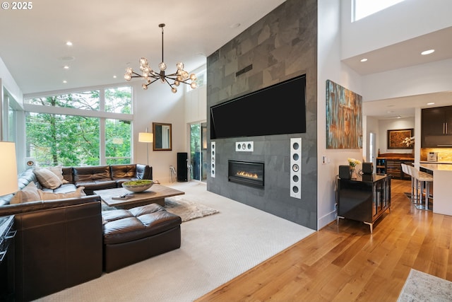 1311 NW 5th Ave, Camas, WA 98607 - living room featuring a towering ceiling, light wood-type flooring, a tile fireplace, recessed lighting, and a chandelier