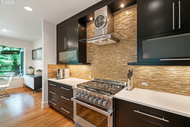 1311 NW 5th Ave, Camas, WA 98607 - kitchen featuring high end stainless steel range, wall chimney range hood, tasteful backsplash, light countertops, and light wood finished floors