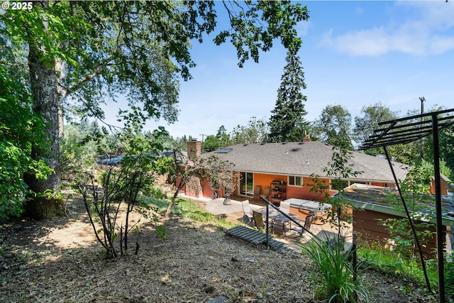 2120 W 23rd Ave, Eugene, OR 97405 - rear view of house with a chimney and a patio area