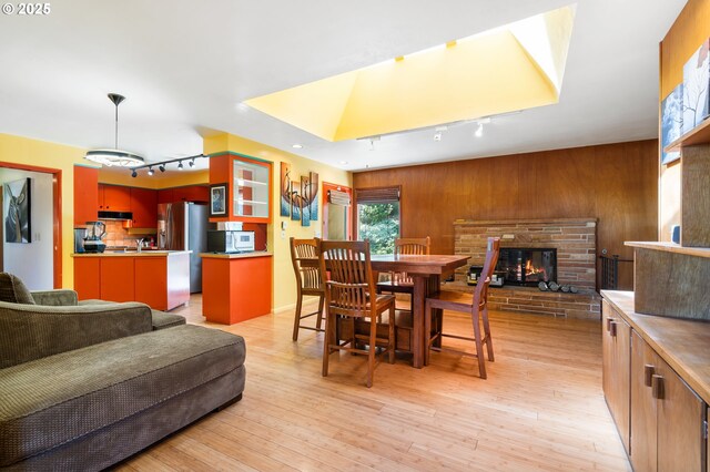 2120 W 23rd Ave, Eugene, OR 97405 - dining room with track lighting, wooden walls, light wood finished floors, and a glass covered fireplace