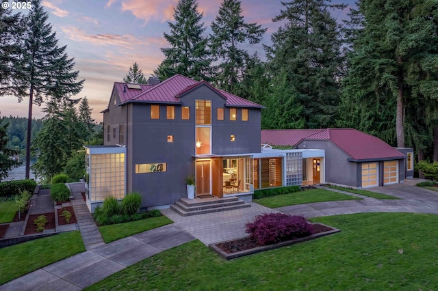 693 Terrace Dr, Lake Oswego, OR 97034 - view of front facade featuring concrete driveway, a garage, a metal roof, a yard, and a standing seam roof