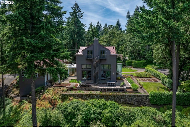 693 Terrace Dr, Lake Oswego, OR 97034 - back of house featuring stairs, a balcony, a patio, a chimney, and a metal roof