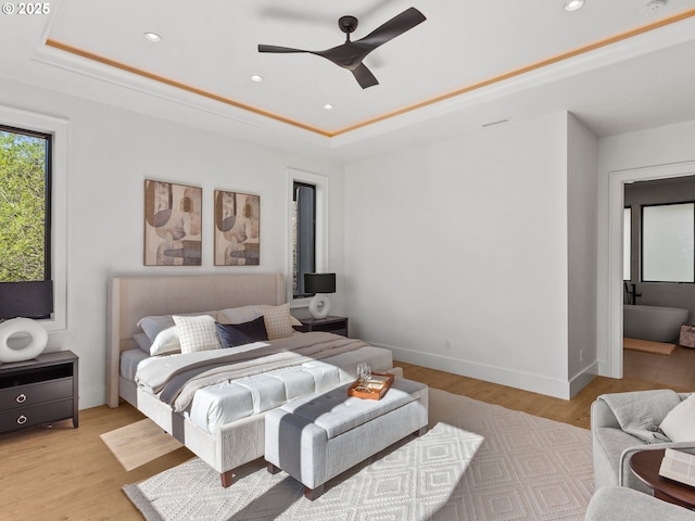 bedroom featuring baseboards, recessed lighting, light wood-style floors, and a raised ceiling