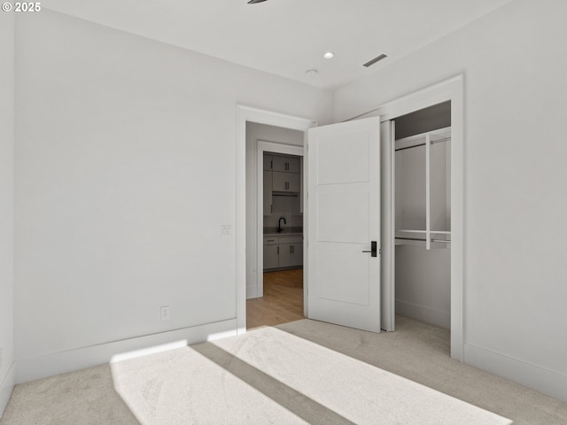 unfurnished bedroom with visible vents, carpet flooring, recessed lighting, and a closet