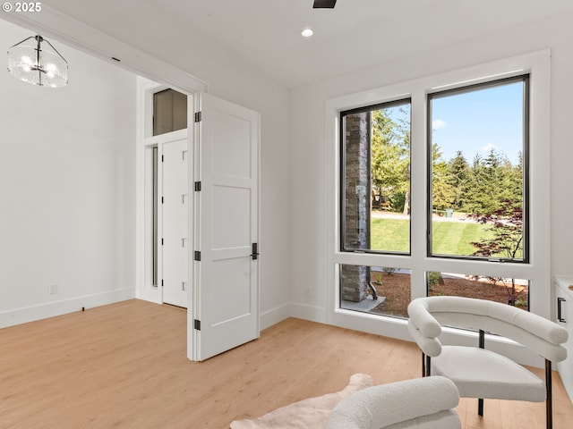 living area featuring recessed lighting, light wood-type flooring, baseboards, and a notable chandelier