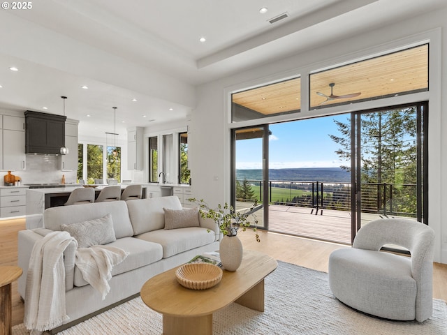 living area with visible vents, recessed lighting, light wood-style floors, and a water view
