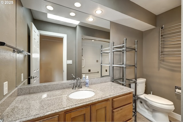 bathroom with recessed lighting, vanity, and toilet