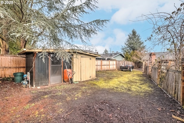 view of yard featuring a shed, an outdoor structure, and a fenced backyard