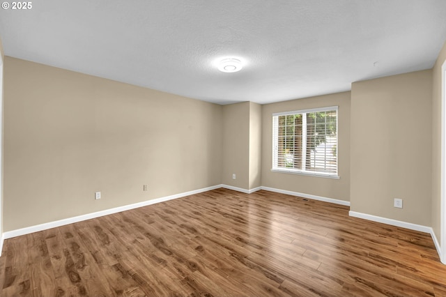 1320 NW Maple Ln, Camas, WA 98607 - unfurnished room with wood finished floors, baseboards, and a textured ceiling