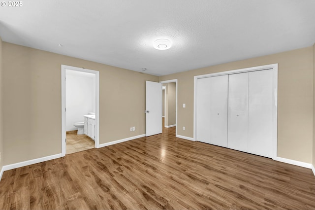 1320 NW Maple Ln, Camas, WA 98607 - unfurnished bedroom featuring light wood-style floors, baseboards, a closet, and connected bathroom