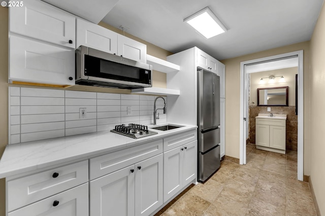 1320 NW Maple Ln, Camas, WA 98607 - kitchen with appliances with stainless steel finishes, open shelves, a sink, white cabinets, and tasteful backsplash