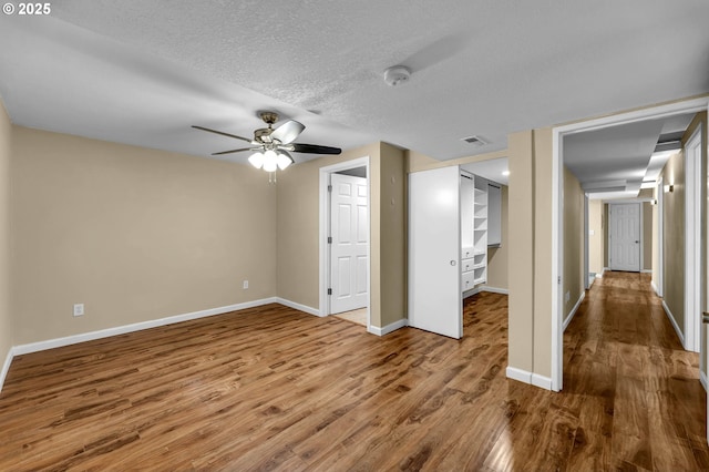 1320 NW Maple Ln, Camas, WA 98607 - unfurnished bedroom with wood finished floors, baseboards, a textured ceiling, a closet, and a ceiling fan
