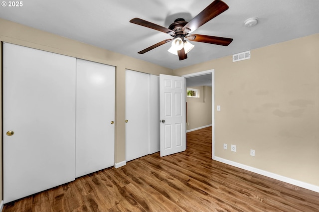 1320 NW Maple Ln, Camas, WA 98607 - unfurnished bedroom featuring wood finished floors, baseboards, multiple closets, and a ceiling fan