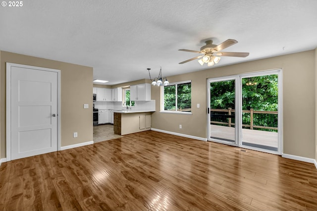 1320 NW Maple Ln, Camas, WA 98607 - unfurnished living room featuring baseboards, ceiling fan, wood finished floors, and a textured ceiling