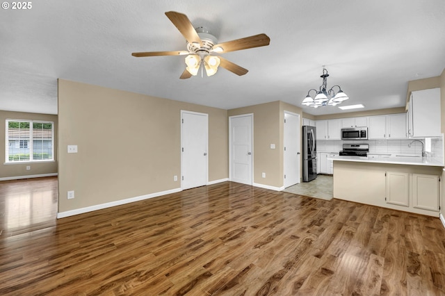 1320 NW Maple Ln, Camas, WA 98607 - kitchen with stainless steel appliances, open floor plan, wood finished floors, a chandelier, and a ceiling fan