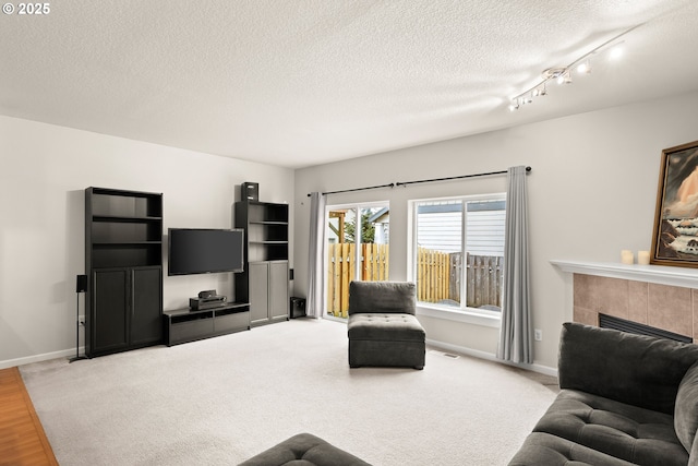 living room featuring a tile fireplace and a textured ceiling