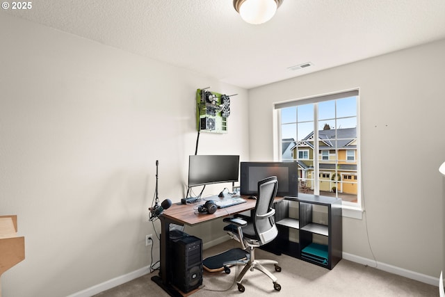 office area featuring light carpet and a textured ceiling