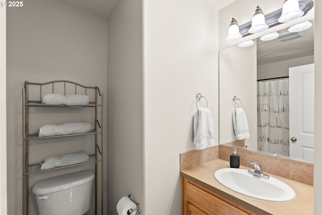 bathroom with vanity, toilet, and decorative backsplash