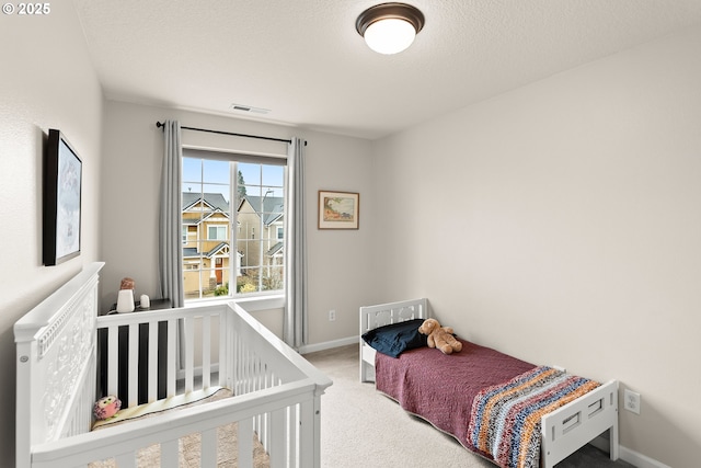 carpeted bedroom featuring a textured ceiling