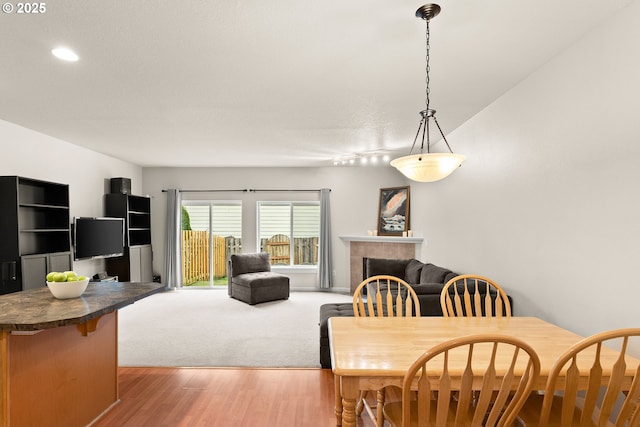 dining area featuring light hardwood / wood-style flooring and a tile fireplace