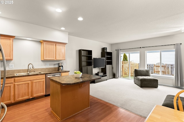 kitchen with dishwasher, a center island, sink, and light hardwood / wood-style floors