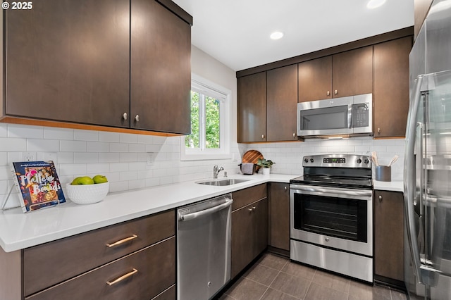 1442 SW 66th Ave, Portland, OR 97225 - kitchen featuring stainless steel appliances, dark brown cabinets, light countertops, decorative backsplash, and recessed lighting