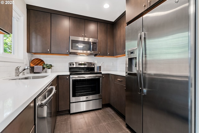 1442 SW 66th Ave, Portland, OR 97225 - kitchen featuring appliances with stainless steel finishes, dark brown cabinets, backsplash, and recessed lighting