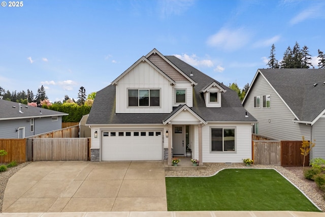 view of front of home featuring board and batten siding, driveway, a front yard, fence, and an attached garage