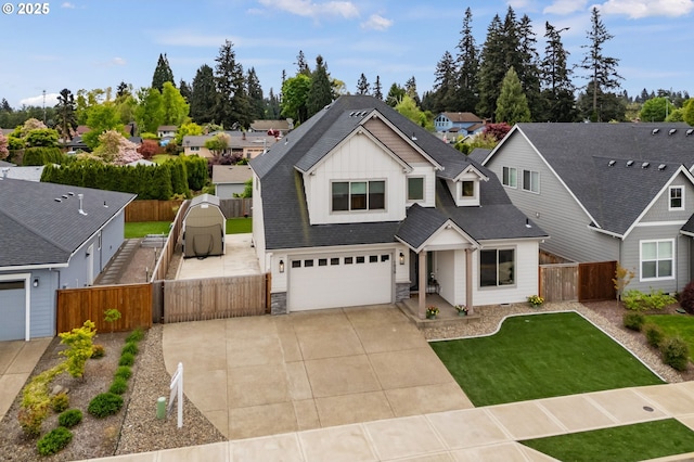 view of front of property featuring a garage, fence, driveway, and stone siding