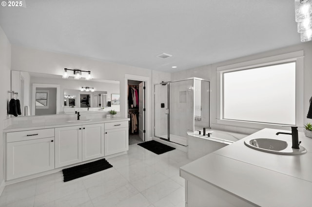 full bathroom with a sink, a stall shower, a garden tub, and two vanities