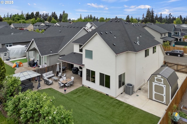rear view of house featuring a residential view, central AC, a shed, an outdoor hangout area, and a patio