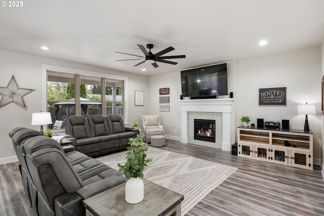 living room with recessed lighting, ceiling fan, wood finished floors, and a fireplace