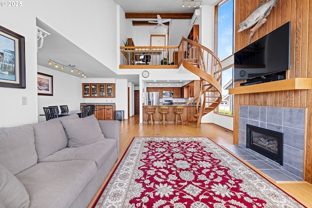 765 5th Ave Unit 5, Hammond, OR 97121 - living area featuring track lighting, stairs, a towering ceiling, light wood-style flooring, and a fireplace