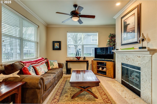 living room featuring ornamental molding, ceiling fan, and a high end fireplace