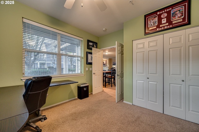 carpeted office space featuring ceiling fan