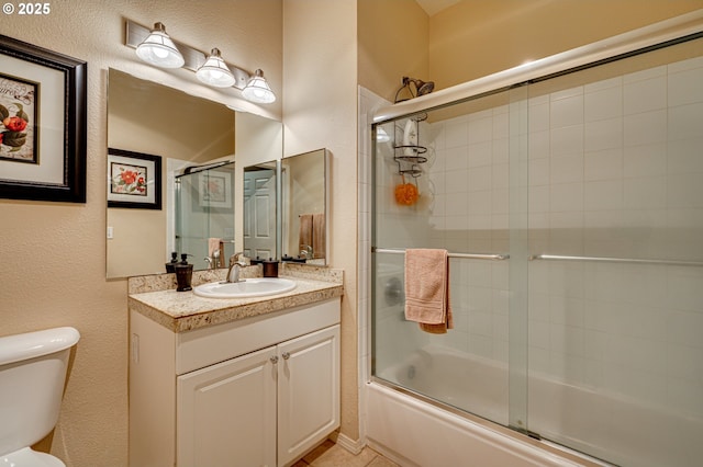 full bathroom with enclosed tub / shower combo, vanity, and toilet