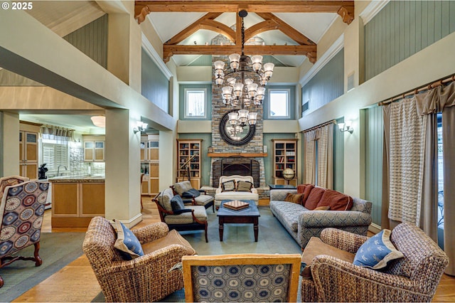 living room featuring high vaulted ceiling, a fireplace, a chandelier, and beam ceiling