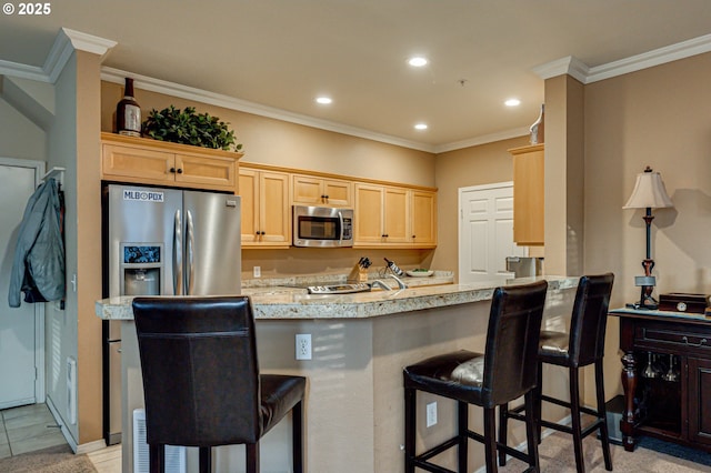 kitchen featuring kitchen peninsula, stainless steel appliances, a breakfast bar, ornamental molding, and light brown cabinets