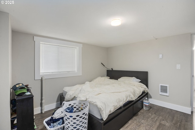 bedroom with wood finished floors, visible vents, and baseboards