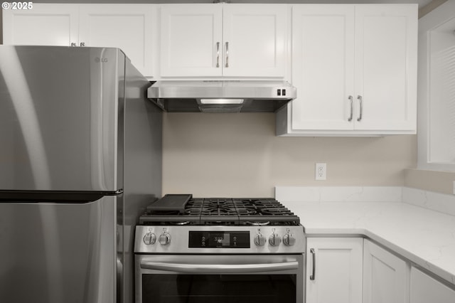 kitchen featuring stainless steel appliances, light stone countertops, white cabinetry, and extractor fan