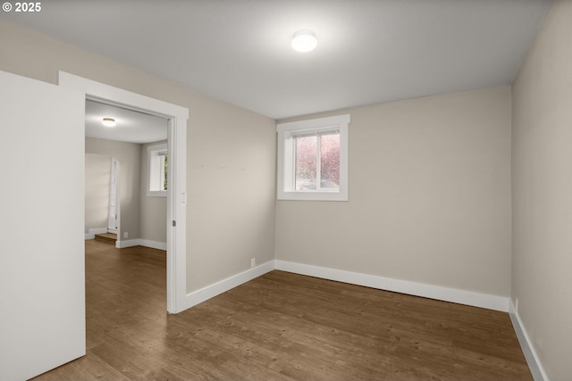 unfurnished room with a wealth of natural light, baseboards, and wood finished floors