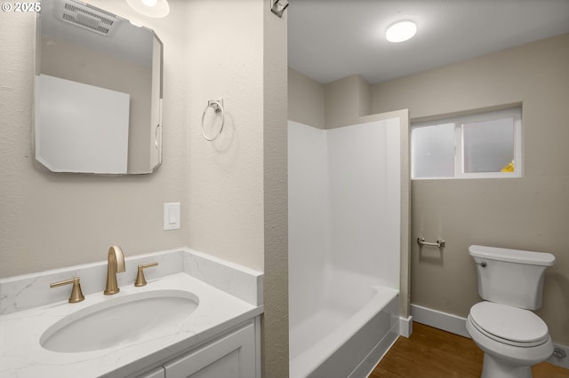 bathroom with toilet, washtub / shower combination, vanity, wood finished floors, and baseboards