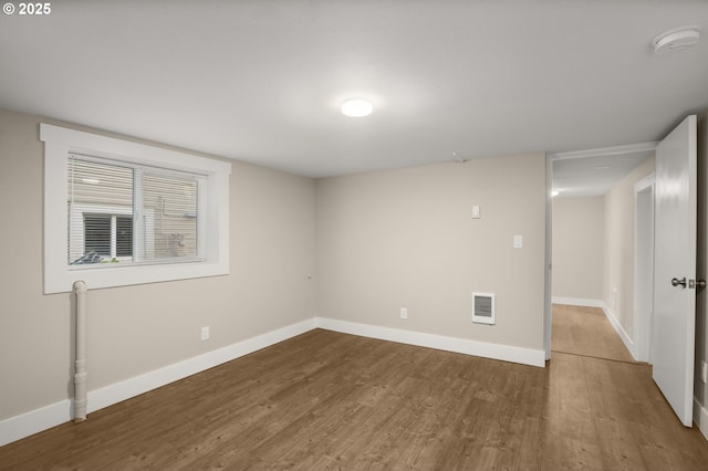 interior space with wood finished floors, visible vents, and baseboards